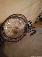 Two bicycle wheels, luggage rack and lock on basement floor