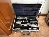 Clarinet disassembled in hard case showing body joints, bell, barrel, mouthpiece and accessories