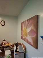 Canvas lotus flower print mounted on wall beside clock