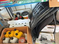 Shelf with six yellow 1-qt oil bottles, various fluids, Schumacher charger box, loose automotive items