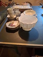 Overview of stacked china, bowls and plates on table