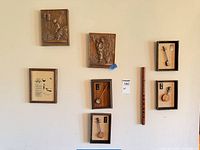 All seven wall pieces including flute, relief plaques, Lakota prayer print, three framed mini instruments