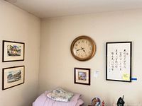 Overall wall view showing clock, calligraphy and multiple framed prints