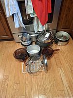 Overview of cookware lot on kitchen floor showing most items