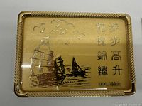 Front view showing ship design, Chinese text, gold colour