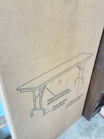 Box showing illustration of folding table with leg design details