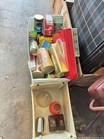 Bin containing assorted tins and additional items
