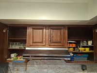 Open cabinets showing glassware, plastic containers, ice cube trays