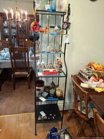 Full view of black metal five-tier shelving unit against wall