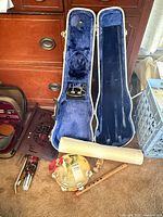 Overall lot showing violin case, tambourine, flute, stand parts, poster