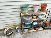 Full view of shelf with assorted planters and supplies