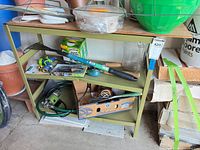 Full view of green metal three-tier shelf, contents not included