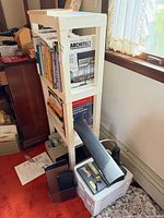 Overall view of white plastic shelf with lamp, stapler, and storage drawers