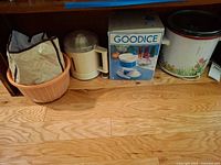 Shelf showing boxed ice shaver, juicer, slow cooker