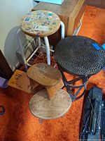 Group shot showing all five stools: hammered metal, white metal frame with stickered seat, rectangular wood step stool, triangular wood stool, round wood stool