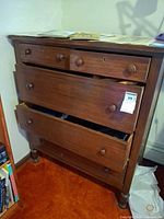Front view of wooden chest showing all drawers and overall condition