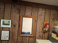 Overall view of wall showing all four items: plug-in sconce, mirror, two framed prints