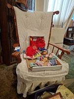 Front view of wooden swivel rocker chair with cushions and slipcover (loose items on seat not included)