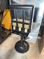 Full view of triple candy vending machine on stand