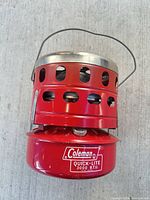 Coleman Quick-Lite 3000 BTU catalytic heater, overall view showing branding, vent holes, handle and stainless top rim