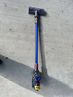 Full view of Dyson cordless stick vacuum showing cleaner head, wand, and motor body