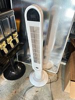 Full view of white tower fan standing on floor