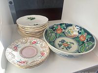 Stack of saucers beside decorative porcelain serving bowl