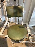 Front view showing scrollwork back, green cushions, full chair structure