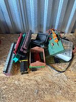 Pile of model train components including track, logs, accessory bases and wiring