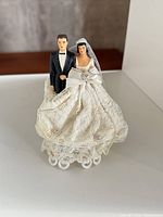 Front view of bride and groom figurines on pedestal