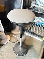 Full view of height-adjustable wobble stool showing grey seat, black post and round wobble base