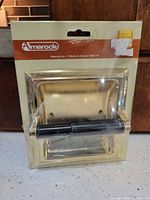 Front view of sealed Amerock recessed toilet paper holder package