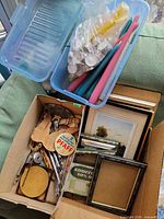 Overall view showing candles, metal tools, wooden pieces, picture frames in box