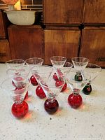 Front view showing all eleven Smirnoff glasses with red and green bubble bases