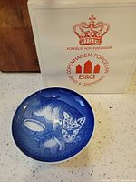 Front view of blue and white cat motif plate with original box