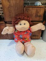 Full view of Cabbage Patch Kids cloth doll seated on counter