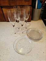 Champagne flutes and glass plates on countertop