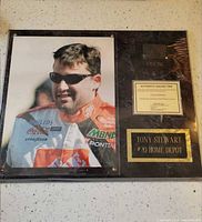 Full view of plaque showing photo, tire fragment, title plate and COA