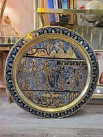 Front view of brass wall plate showing Egyptian scene