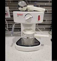 Front view of Multichef espresso cappuccino maker with portafilter resting on top and glass carafe in place