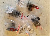 Four sealed Richelieu packages containing black square cabinet pulls