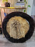 Front view of circular fur hide dreamcatcher showing tan centre and dark brown border