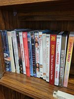 Shelf row showing majority of DVD spines including Christmas with the Kranks, Running with Scissors, Rumor Has It…, Encore and others