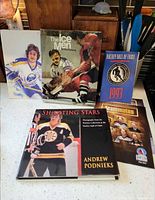 Stacked hockey books, Hall of Fame booklet, autographed photo