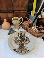 All items grouped: decorative plate, mug, wicker basket, terracotta jar, metal holder, wooden boxes