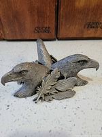 front view showing three eagle heads and feather pieces