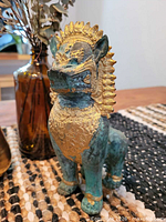 Front three-quarter view of bronze gilt Singha guardian
