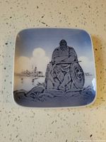 Front view of square porcelain dish showing Viking motif