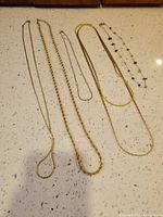 All five necklaces laid out to show full lengths and styles