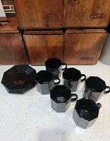 Six mugs and six saucers displayed together